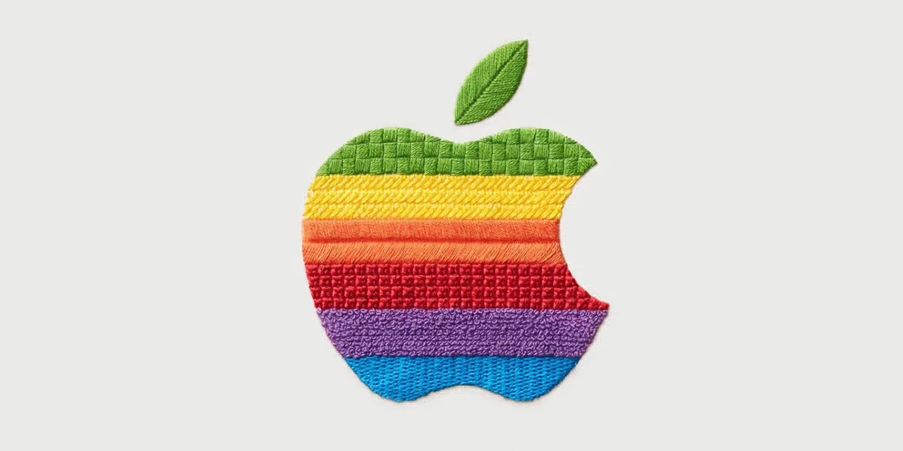 灰色の布地に、緑、黄、赤、青などの糸で刺繍されたAppleのリンゴのロゴ。糸の向きや立体感が見える。