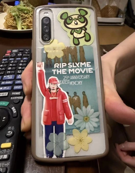 透明なスマホケースに音楽のグッズと、CRUNKYのネックレスを着けた安全ディギーの印刷素材を入れた、kumiyotogeさんの公開投稿写真。